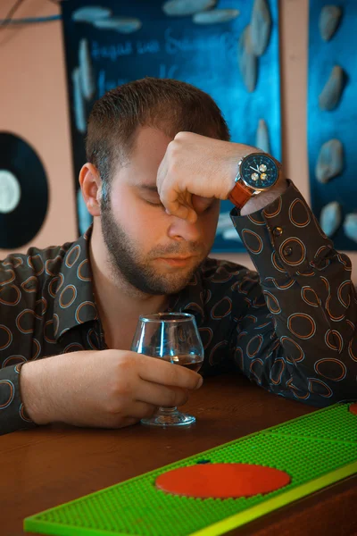 Dronken man aan de bar drinken cognac van glas — Stockfoto