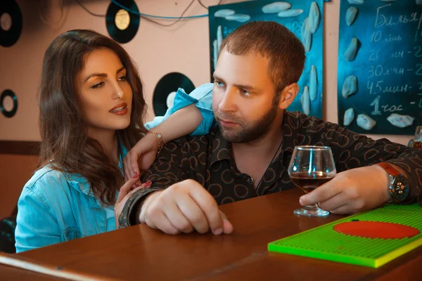 Drunk guy flirting with a beautiful brunette in a bar — Stock Photo, Image
