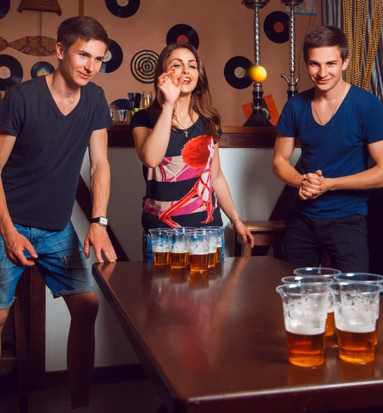 Belle fille brune s'amuser avec des jumeaux jouer à la bière pong Images De Stock Libres De Droits