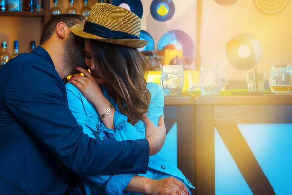 Unshaven man says girlfriend's ear, and she laughs at the bar — Stock Photo, Image