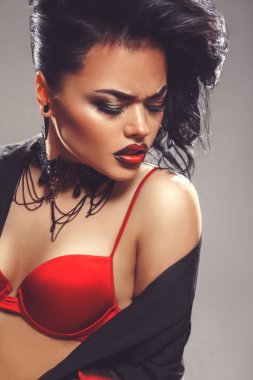 Sexy adult woman with closed eyes and make up in red bra
