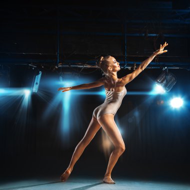 Caucasian blonde ballerina posing on stage
