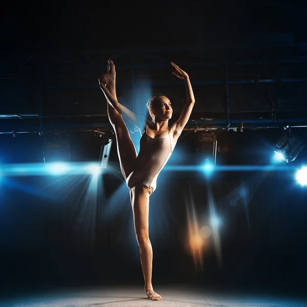 Nice adult ballerina posing on stage of theater — ストック写真