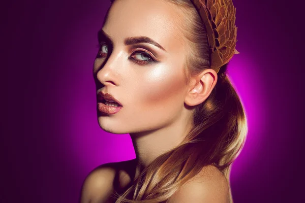 Bela jovem com maquiagem profissional no backgro roxo — Fotografia de Stock