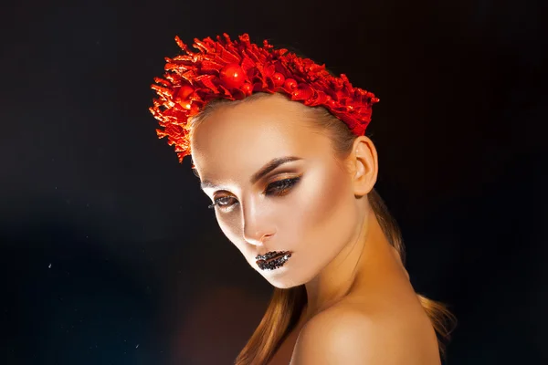 Sexual young woman with red wreath on headn on black background — Stockfoto