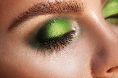Close up photo of closed eyes with green makeup