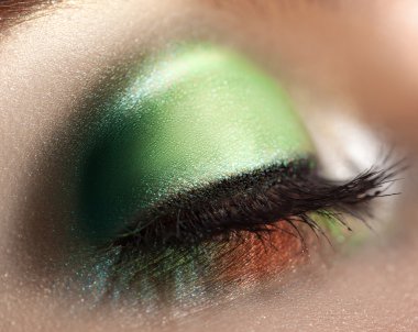 close up photo of closed woman eye with green makeup