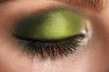 macro picture of closed eye with green colors makeup