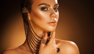 Pretty female with accessories and green makeup in studio