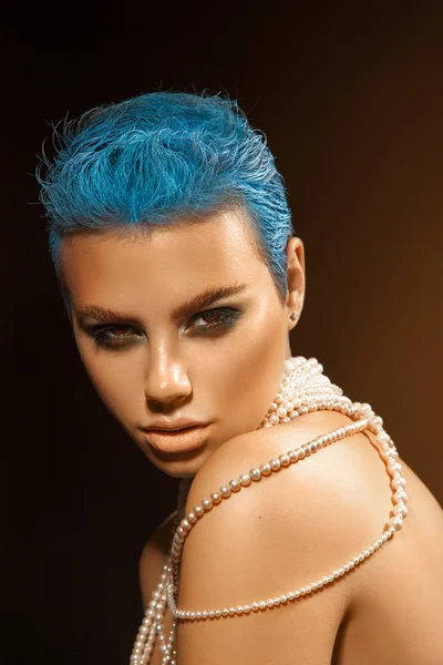 Nice young adult woman with short blue hairstyle and pearls on n — Stockfoto