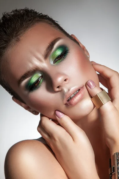 Modelo de moda seria con hermoso maquillaje verde mirando hacia abajo — Foto de Stock