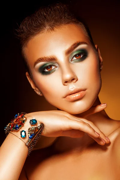 Vertical portrait of young woman with green colors makeup and ac — Stock Photo, Image