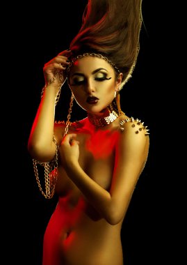 Slim sexual woman with golden accessories and high creative hair