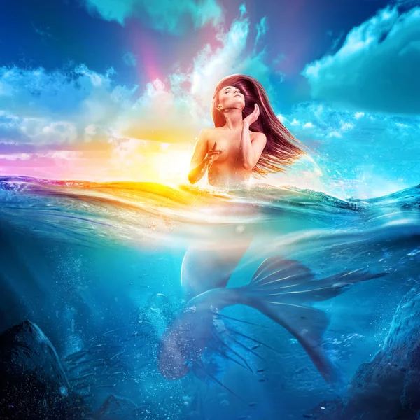 Sexy mermaid emerges out from sea at sunset — Stock Photo, Image