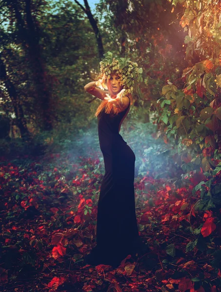 Adorable young witch casts a spell in the woods — Stock Photo, Image