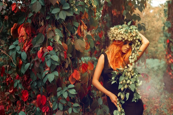 本社屋内にホップの花輪を持つ赤毛の少女の肖像画 — ストック写真