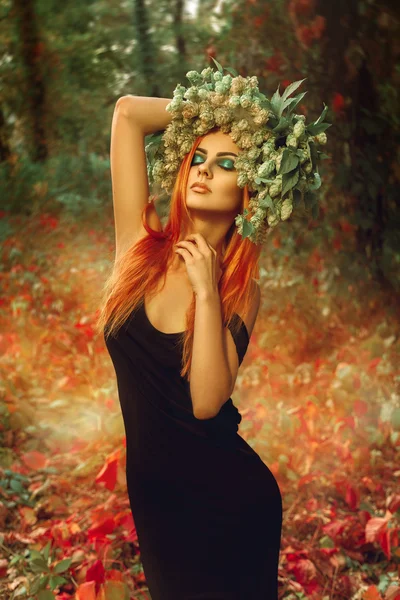 Sexual slim lady with wreath of hop on head in forest posing — Stock Photo, Image