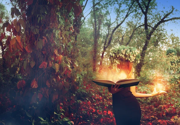 Junge Rotschopf atemberaubende Hexe liest Zauberbuch im Wald — Stockfoto