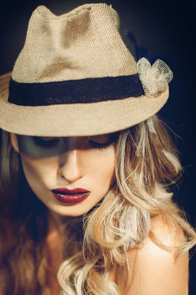 Sexy ragazza adulta con bel trucco in elegante cappello guardando verso il basso — Foto Stock