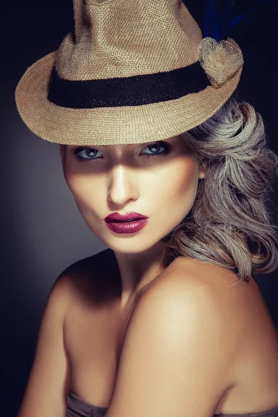 Mujer con hermoso maquillaje y sombrero elegante mirando a la cámara — Foto de Stock