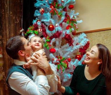 Mutlu Noel ailesiyle küçük bebeği. Ebeveyn gülümseyen bir