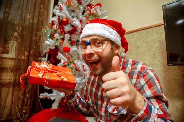 Funny nerd in santa hat gets a christmas gifts — Stock Photo, Image