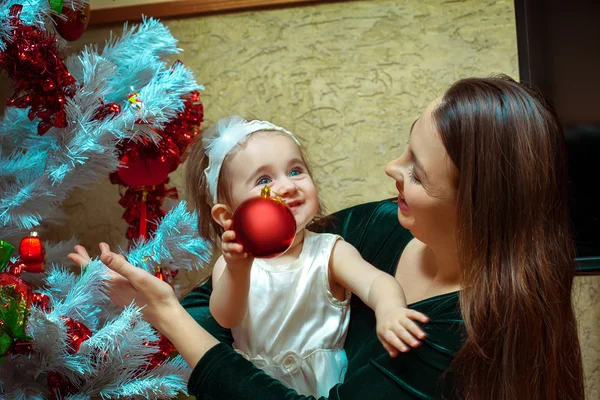 Krásná malá holčička s modrýma očima zdobí vánoční — Stock fotografie