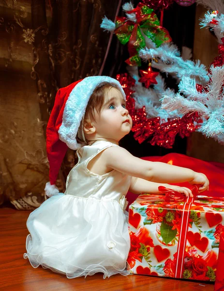 Cute dziewczynka dziecko w Stana kapelusz otwiera jej pierwsze Boże Narodzenie pre — Zdjęcie stockowe