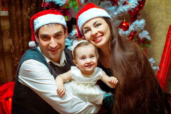 Glückliche Weihnachtsfamilie mit kleinem Mädchen — Stockfoto
