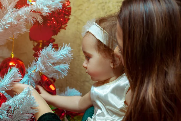 Matka se vánoční strom zdobí její holčičku — Stock fotografie