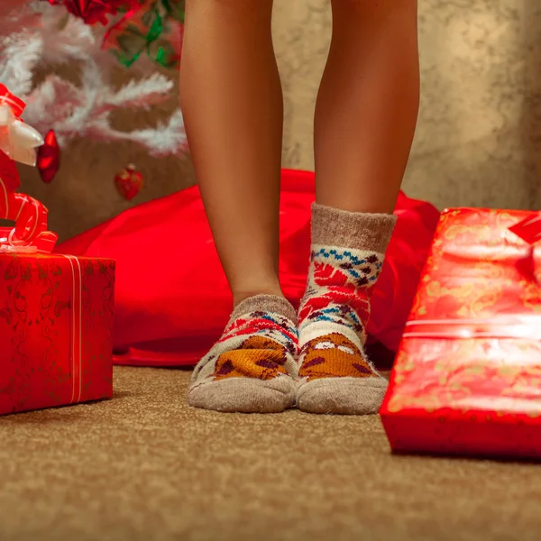 Сексуальные женские ноги в веселых носках с большим количеством рождественских подарков — стоковое фото
