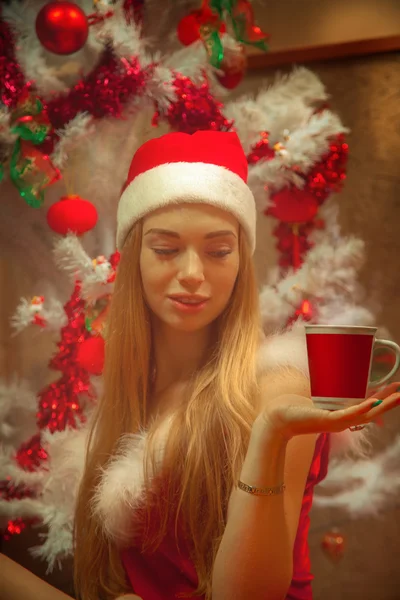 Humor de Natal. Menina bonita e bebida quente em copo vermelho — Fotografia de Stock