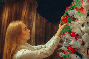 Genç seksi kadın süslenen bir Noel ağacı