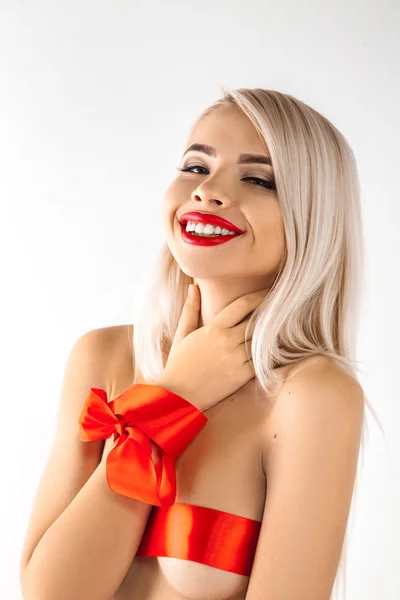 Portrait of charming smiling blonde woman with red ribbons on bo — 图库照片