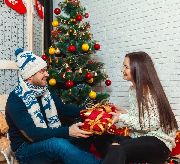 Pareja agradable se da regalos para la Navidad —  Fotos de Stock