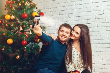 loving young couple making Christmas selfie clipart