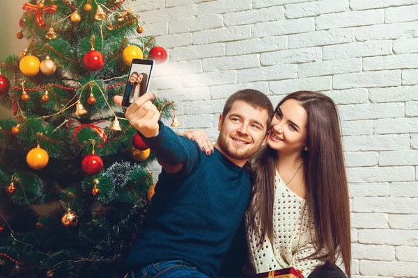 Kärleksfull ungt par att göra jul selfie — Stockfoto