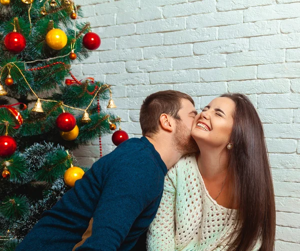 男人亲吻一个女孩在树下在圣诞节 — 图库照片