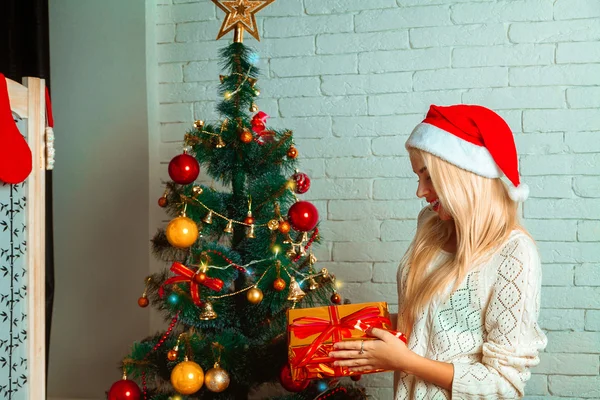 Blonde öppnar sin julklapp — Stockfoto