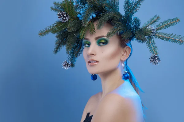 Nice serious woman with xmas tree-wreath on head looking at came — Stock Photo, Image