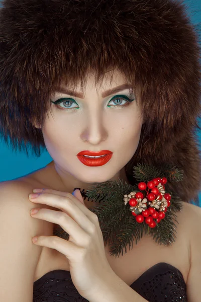 Pretty girl in a fur hat and a Christmas tree in the neck — Stock Photo, Image