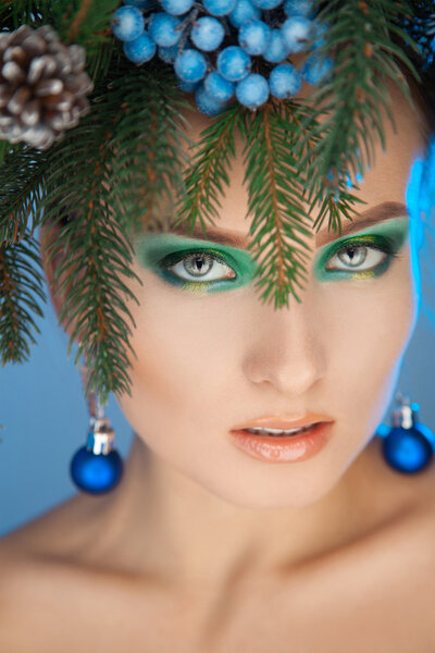 Vertical photo of sexy young woman with wreath-tree on head at c