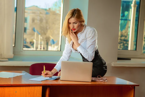 Obchodní lady píše dokumenty a mluvící telefon v kanceláři — Stock fotografie