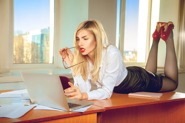 Secretaria de oficina rubia sexual en camisa posando sobre la mesa — Foto de Stock