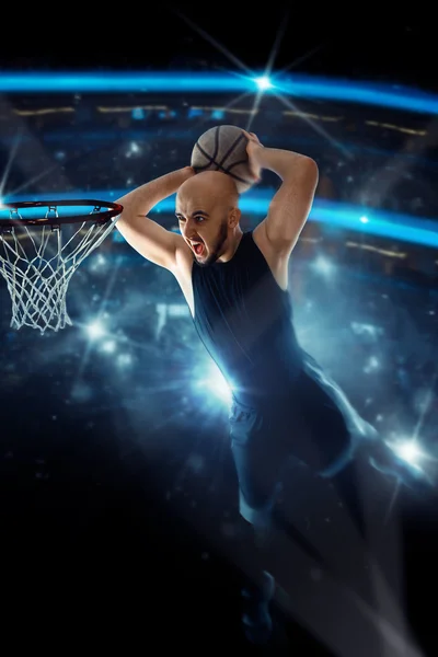 Basketbalspeler in zwarte trui maakt een slam dunk in het spel — Stockfoto