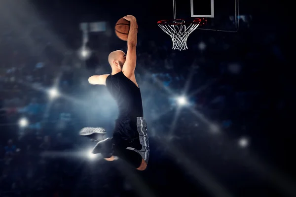 Jugador de baloncesto saltando al ring y hace slam dunk — Foto de Stock