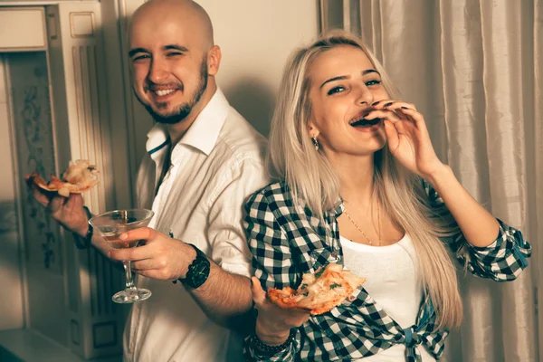 Lustiges Paar lacht auf einer Party mit Pizza — Stockfoto