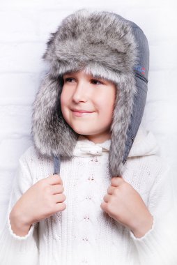 Sıcak kürk şapkalı çocuk gülümseyen