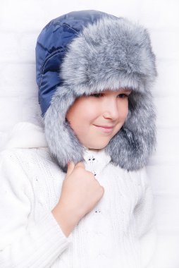Sıcak kürk şapkalı çocuk gülümseyen