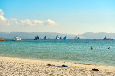 Boracay, Filipinler - 29 Ocak 2020 Boracay adasının beyaz plajı. Turistler plaj boyunca yürür ve denizde yüzerler. Coronavirüs salgınından birkaç gün önce.